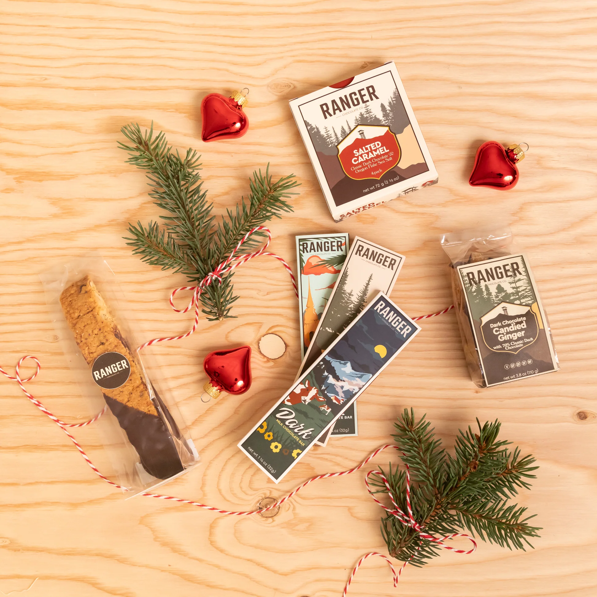 Ranger chocolate bars and specialty treats arranged with evergreen branches and red ornaments