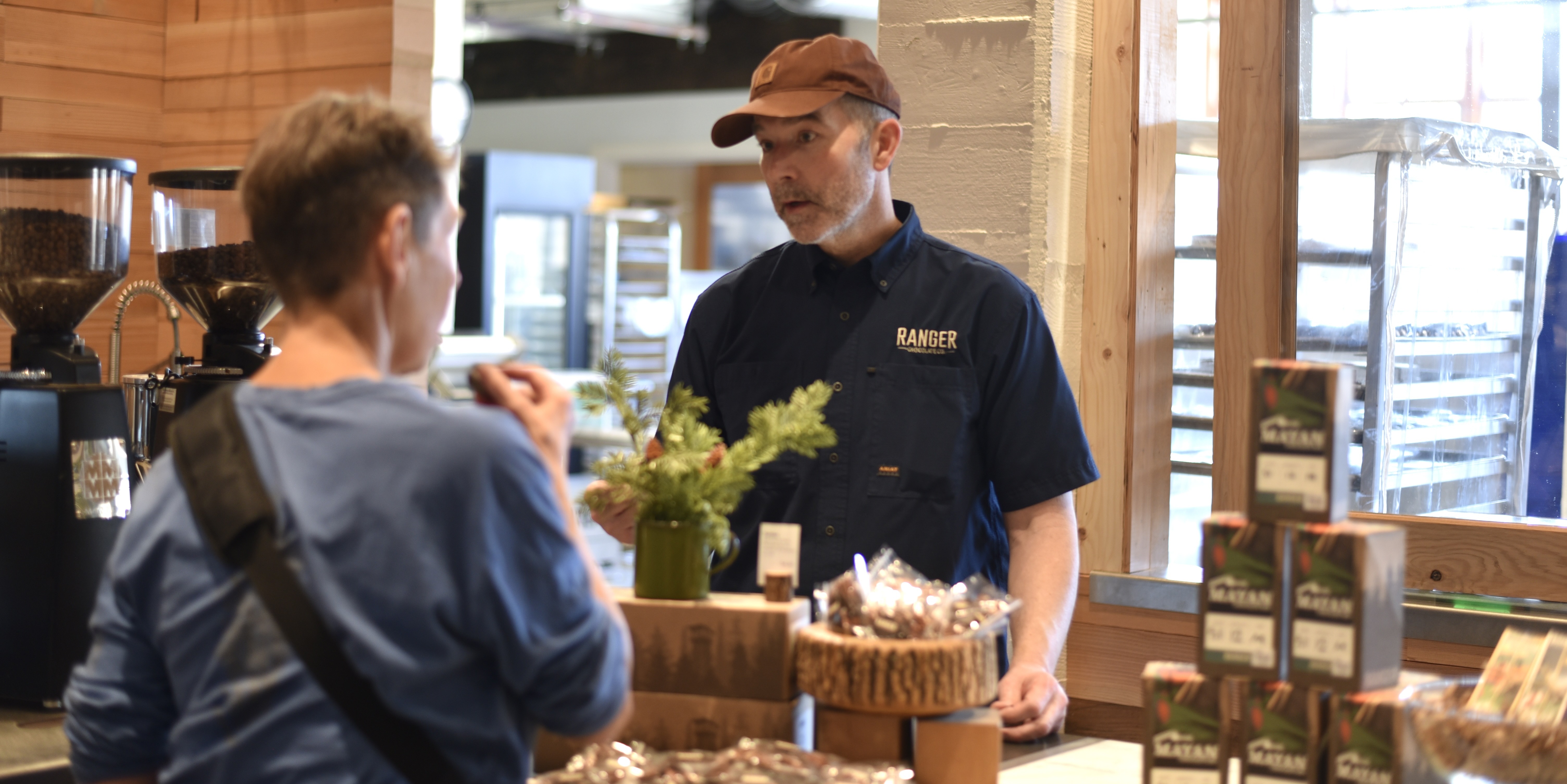 Ranger Chocolate Co. co-founder George Domurot talking with a customer at the tasting counter