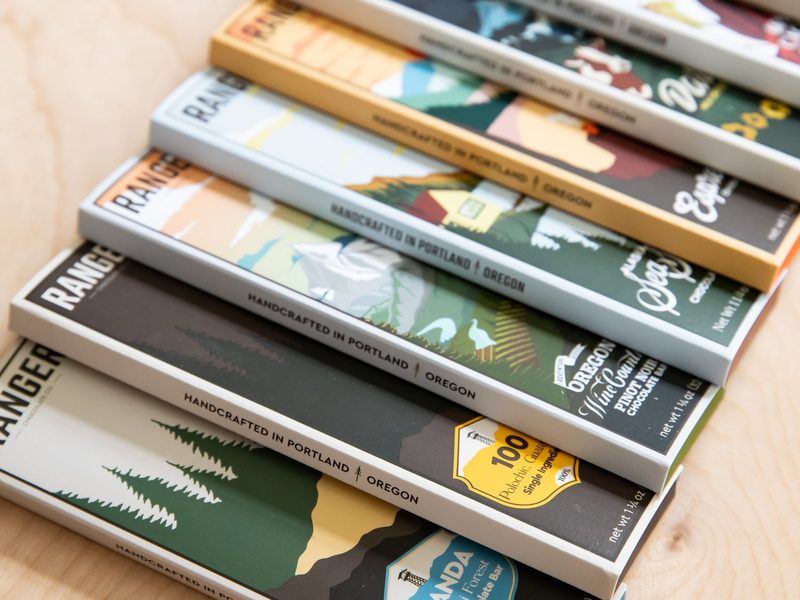 A stack of Ranger chocolate bars in different flavors laid out on a wooden table